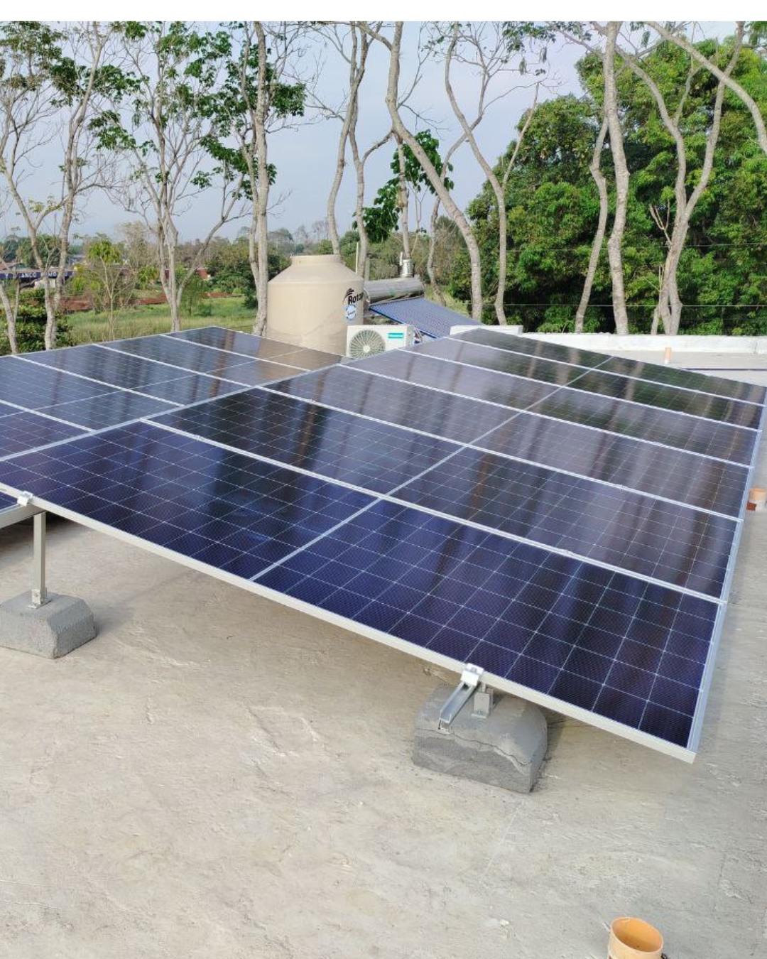 Paneles solares sobre estructura en azotea con tanque de agua